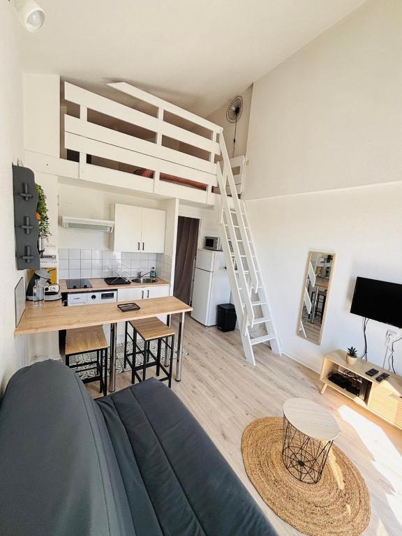 Il comprend une cuisine et un salon avec une mezzanine. dans l'établissement Duplex cosy neuf - wifi - balcon - en bordure de forêt de pins - proche plage, à Saint-Jean-de-Monts