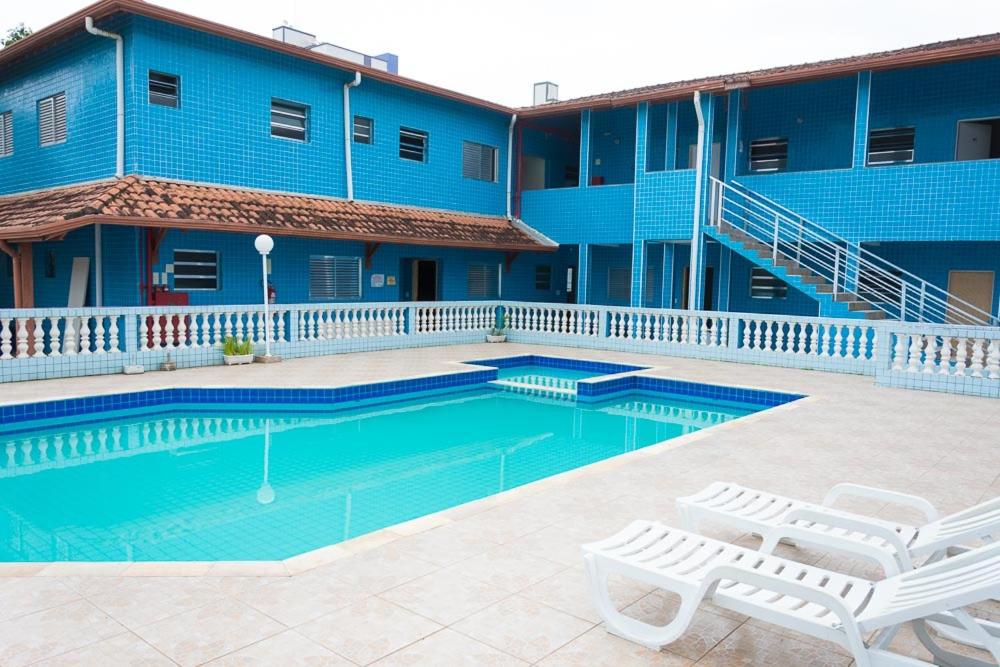 una piscina frente a un edificio azul en Chalé Jofisa, en Praia Grande