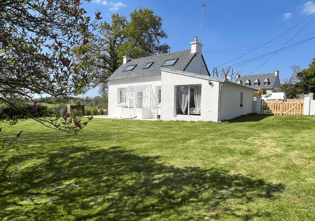 une maison blanche avec une grande pelouse dans l'établissement Chez Josie, cottage en Bretagne, à Bannalec