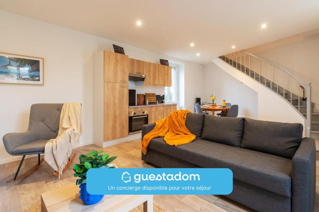 ラヴァルにあるLakaz - Maison - Jardin - Wifiのソファとキッチンのあるリビングルーム