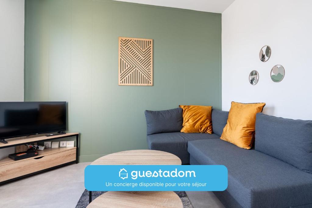un salon avec un canapé bleu et une télévision dans l'établissement Le Rivage - Wifi - Centre-ville, au Mans