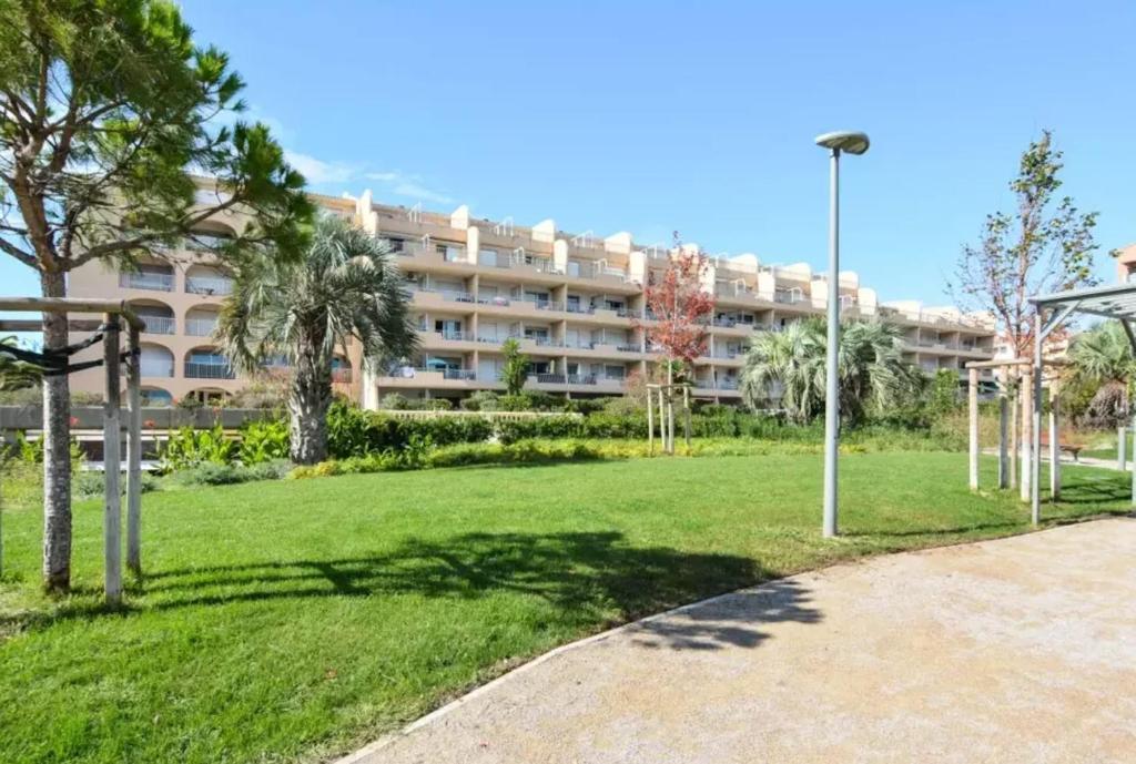 un grand immeuble avec un parc en face dans l'établissement Charmant studio à Hyères avec balcon - 25 m², à Hyères