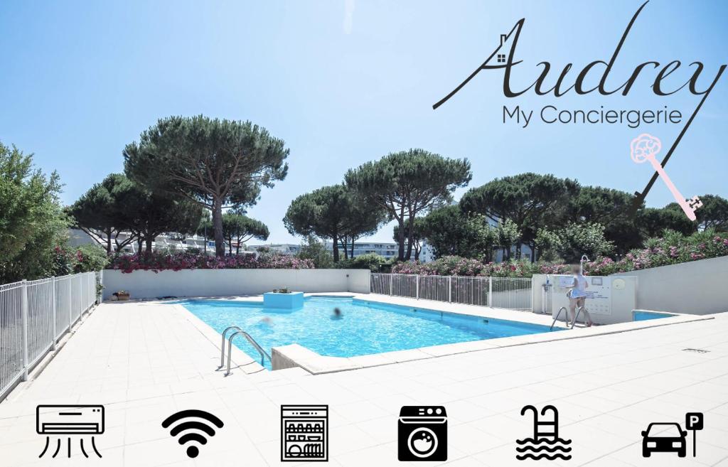 une piscine dans une cour avec des arbres en arrière-plan dans l'établissement Chez Hervé - Charmant appartement avec piscine et parking, à La Grande Motte