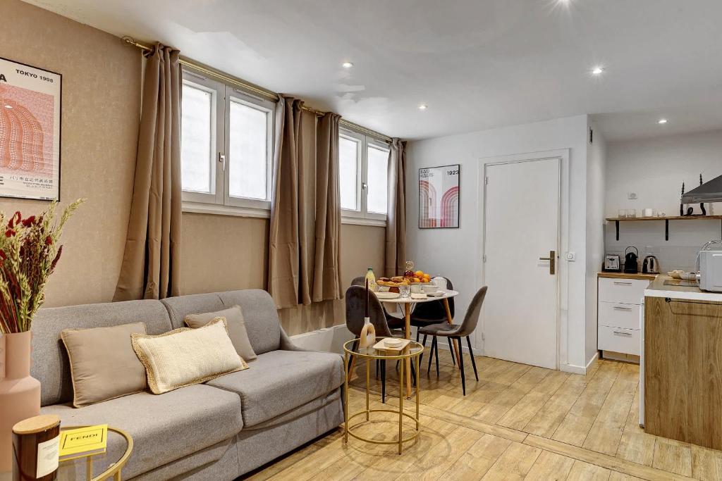 un salon avec un canapé et une table dans l'établissement Charme Parisien pres des Buttes-Chaumont, à Paris