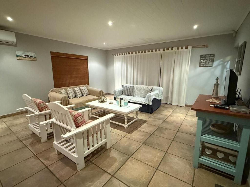 a living room with a couch and a table at Barking Beach Cottage, Sandbaai - Pet Friendly in Hermanus