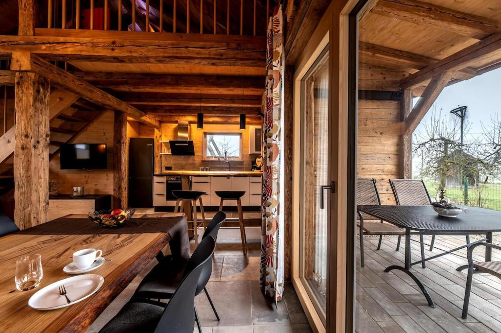 una sala da pranzo e una cucina in una baita di tronchi di Ferienhaus Fichtenzauber - Naturidylle am Wildgehege & Pfrunger Ried - Nähe Bodensee a Riedhausen