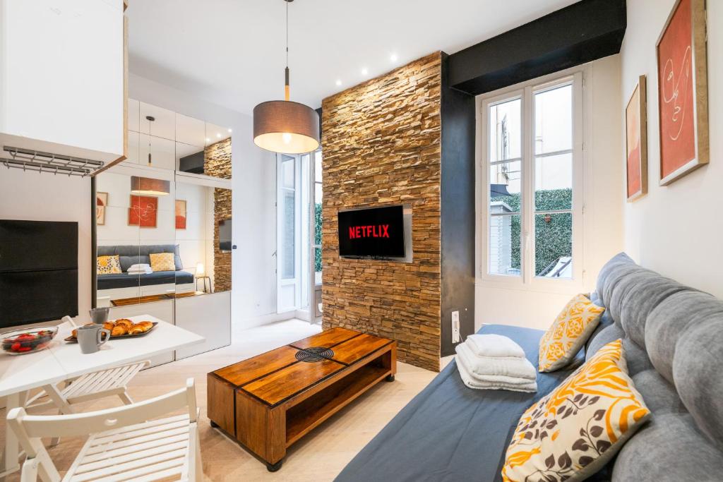 un salon avec un canapé et une table dans l'établissement Charme Niçois avec terrasse en ville, à Nice