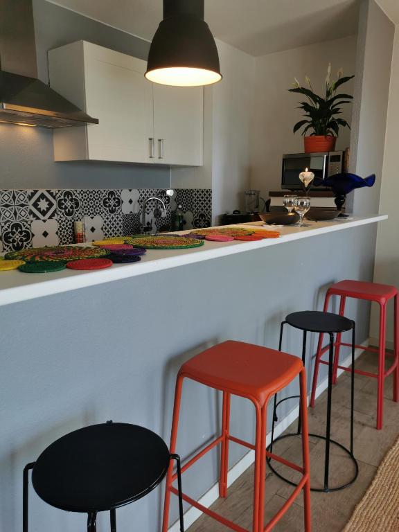 a kitchen with two red stools and a counter at Chez Sab in Saint-Fons