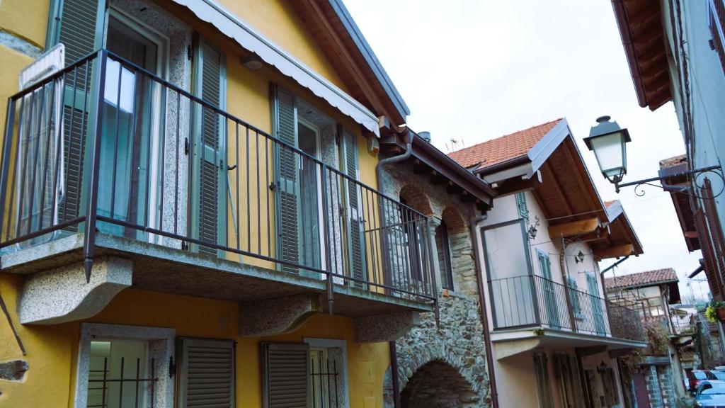 a yellow building with balconies on the side of it at Ciceri Properties Sandrin in Mergozzo