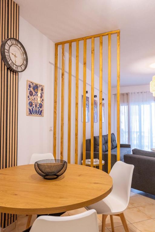 a dining room with a table and a clock at Arline's Luxury Retreat House in Sarandë