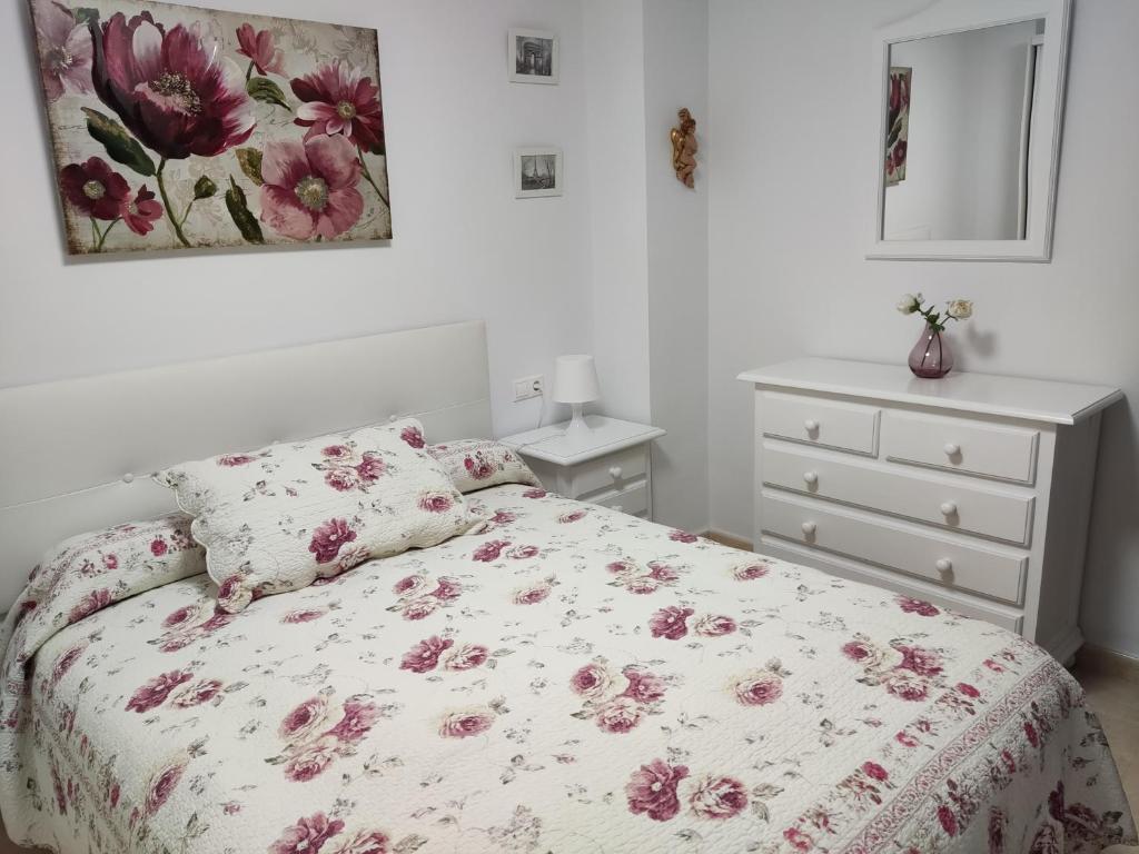 プラド・デル・レイにあるVivienda Rural Casa Anaのベッドルーム1室(ピンクの花が咲くベッド1台付)