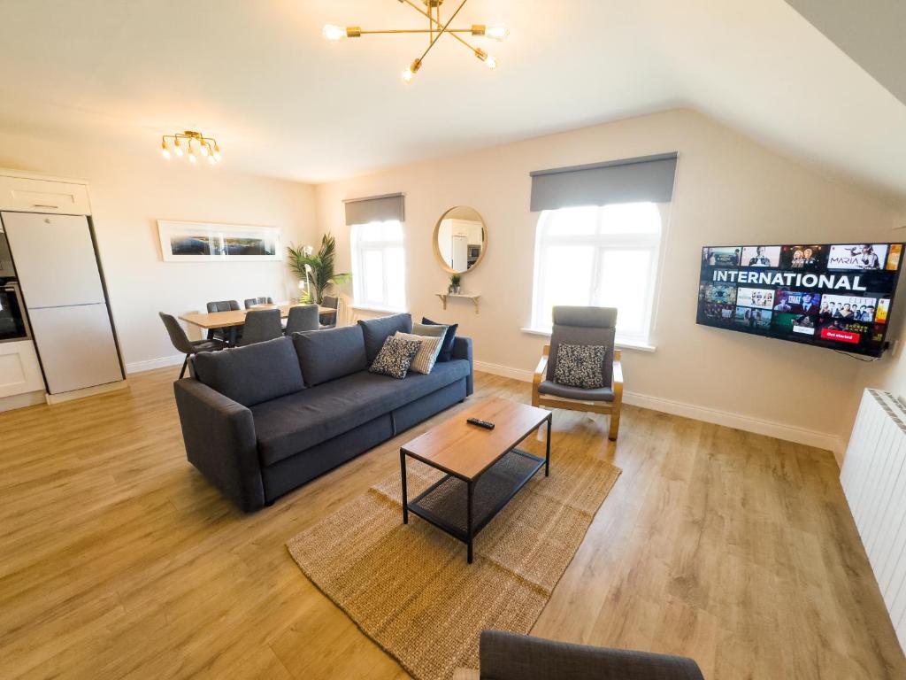 a living room with a couch and a table at Luxury Penthouse Apartment overlooking Main Beach in Bundoran