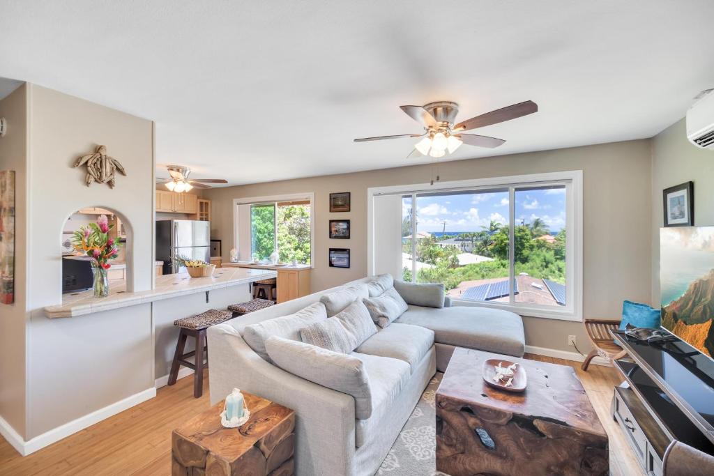 a living room with a couch and a table at Hale Kahana'lu in Koloa