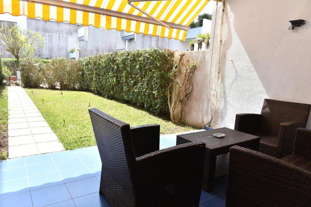 Un patio con sillas, una mesa y una sombrilla. en CASA LUPO - Nelle Maldive Del Salento, en Fontanelle
