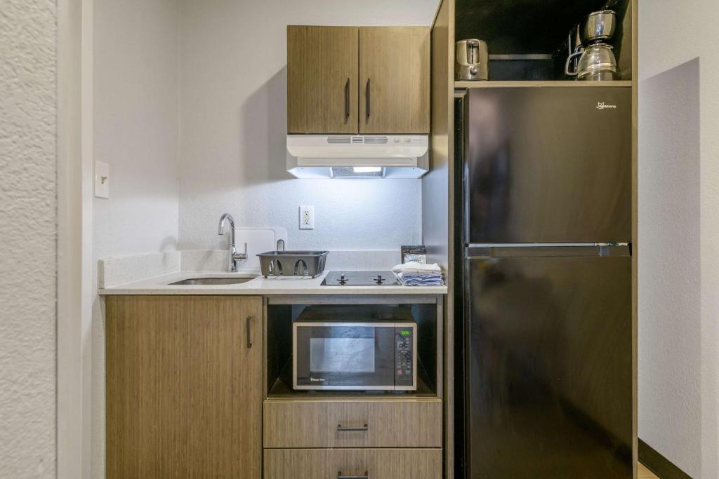 a small kitchen with a stainless steel refrigerator at Studio 6 Columbus GA Columbus Airport in Columbus