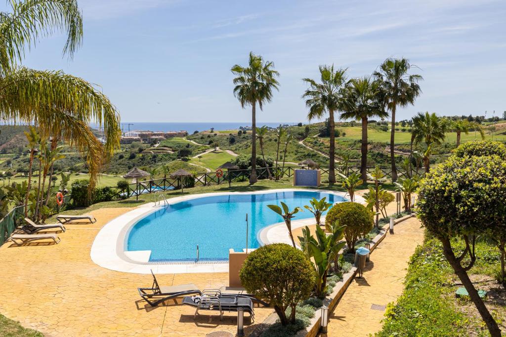 a swimming pool in a resort with palm trees at Apartment with Private Terrace Calanova Golf by AORA STAY in Mijas Costa