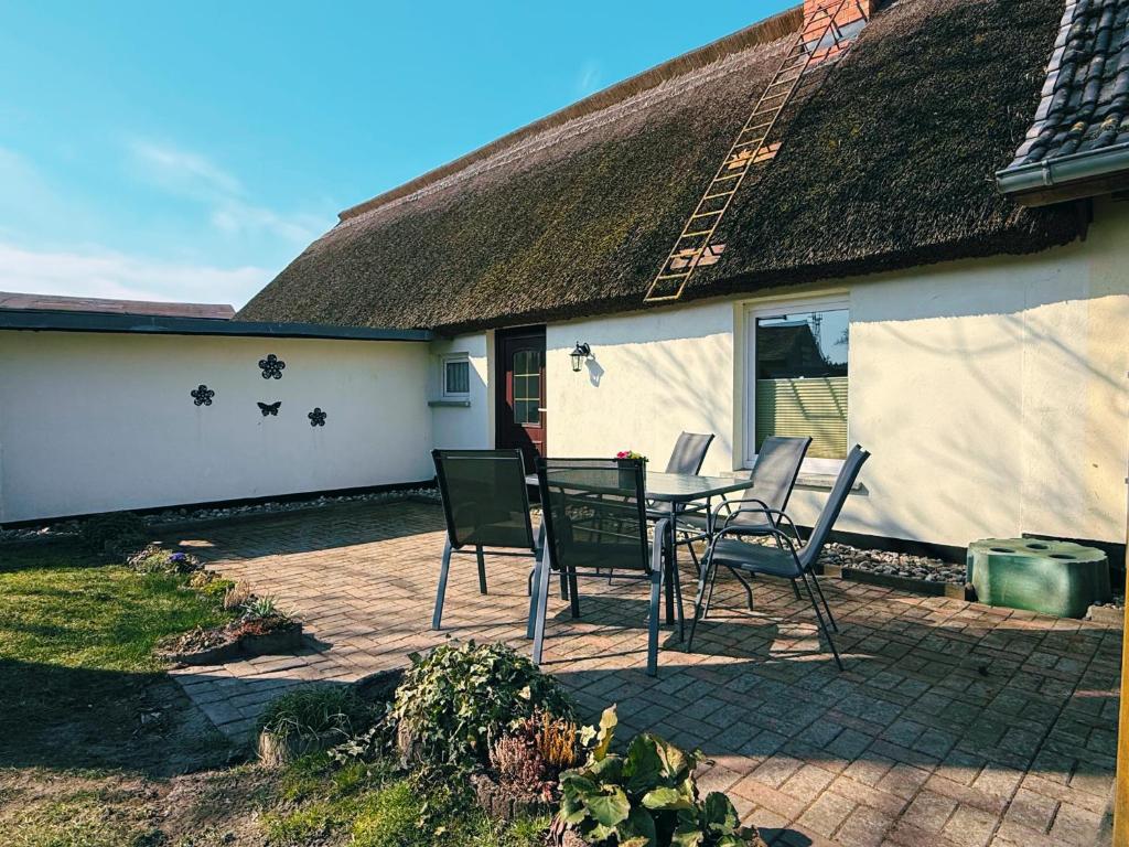 a patio with a table and chairs in front of a house at Ferienwohnung 2 Wald & See in Zirchow