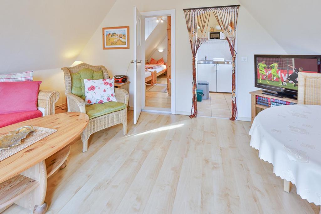 a living room with a couch and a tv at Ferienwohnung Heideweg, OG in Zingst