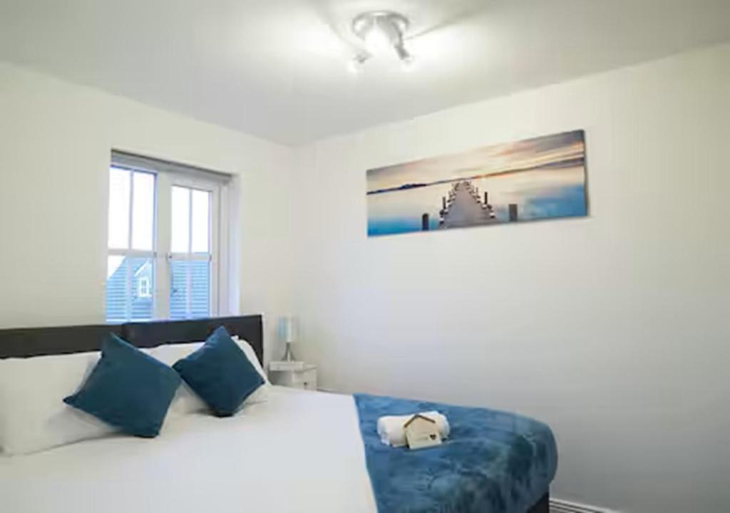 a bedroom with a large bed with blue pillows at 5 Bedrooms, Sleeps 10, Free Parking, Near NEC & Airport, Contractors in Solihull
