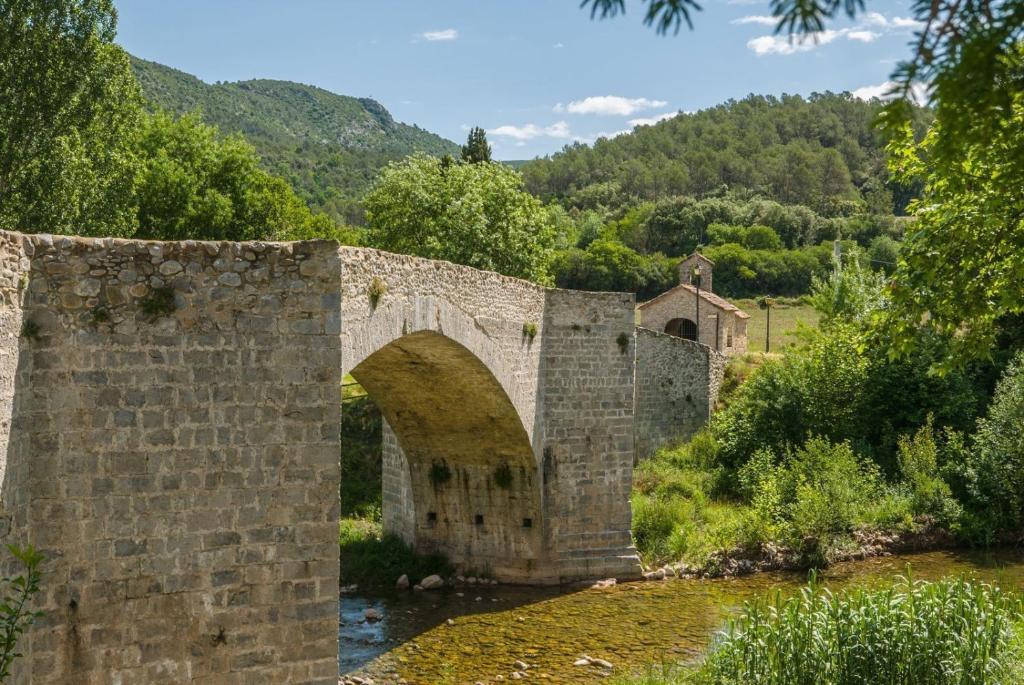 an old stone bridge over a river at Sant Llorenç de la Muga, Empordà, Alta Garrotxa in Sant Llorenç de la Muga