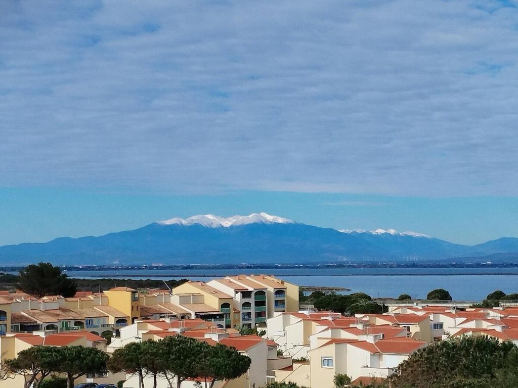 Une ville avec des maisons et une montagne en arrière-plan dans l'établissement Front de Mer T2, au Barcarès