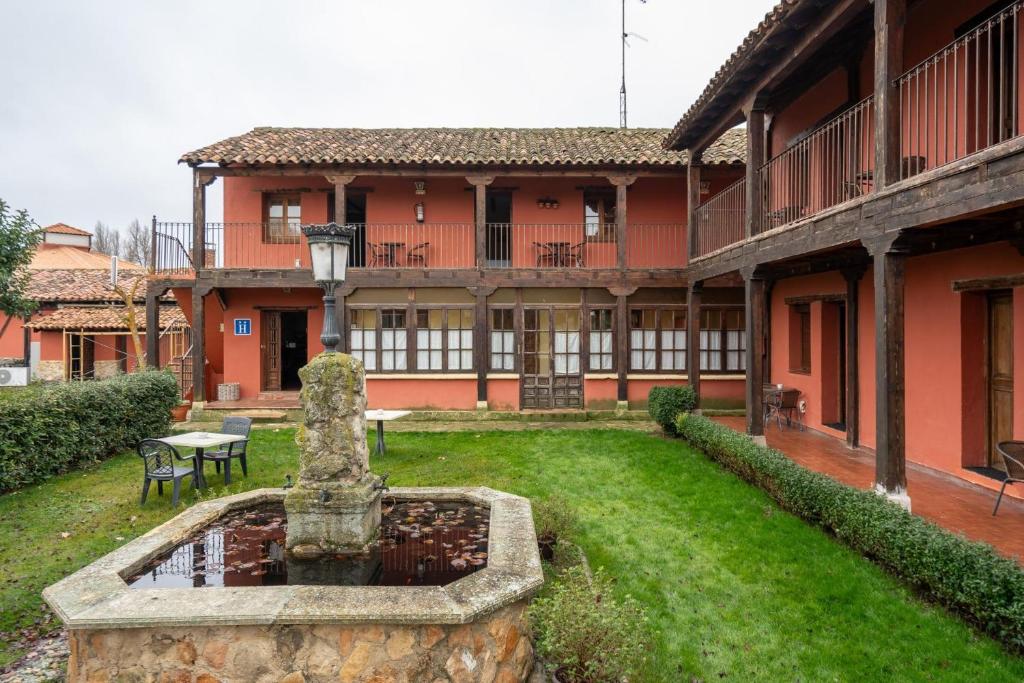a courtyard with a fountain in front of a building at Hotel Los Rastrojos in Sinovas