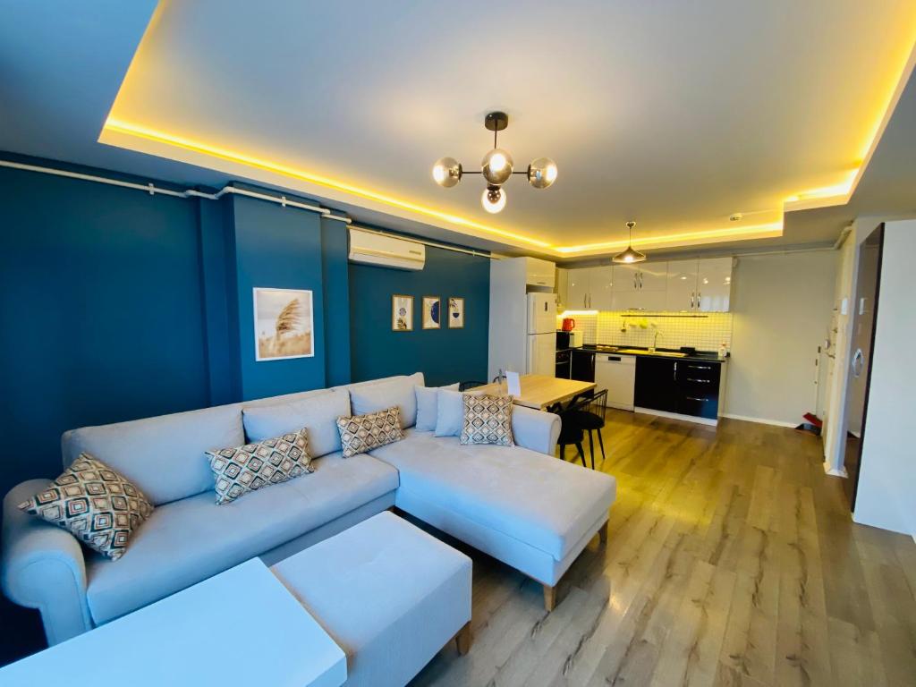 a living room with a white couch and a blue wall at Royal Loft Suit in Antalya