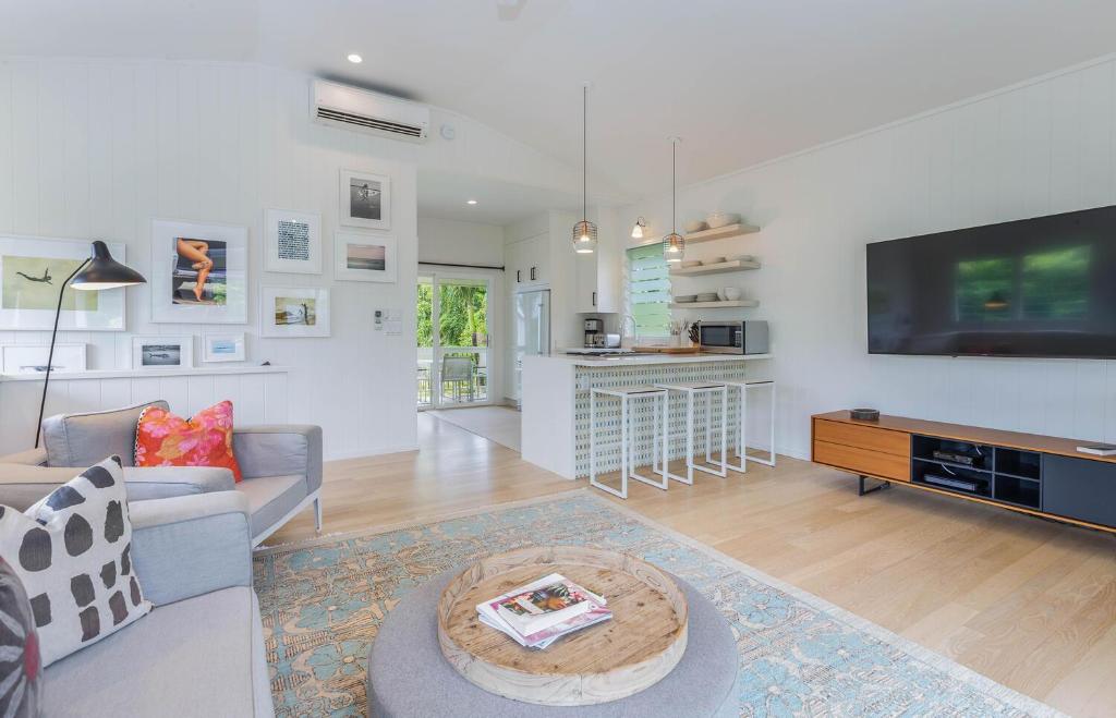 哈纳莱伊Pinetrees Hanalei Cottage的客厅里有一张沙发和一台电视