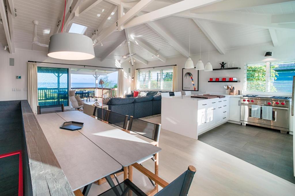 Una cocina y una sala con una mesa y un comedor. en Pinetrees Hanalei Beach House, en Hanalei