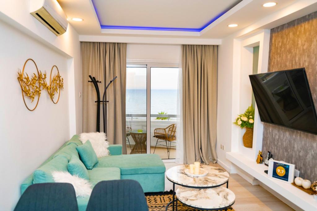 een woonkamer met een blauwe bank en een televisie bij Lazuli Sea View Beachfront Ap 21 in Larnaka