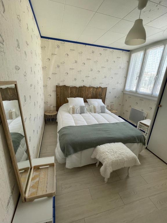 une chambre avec un grand lit et un miroir dans l'établissement Les Dunes, à Saint-Hilaire-de-Riez