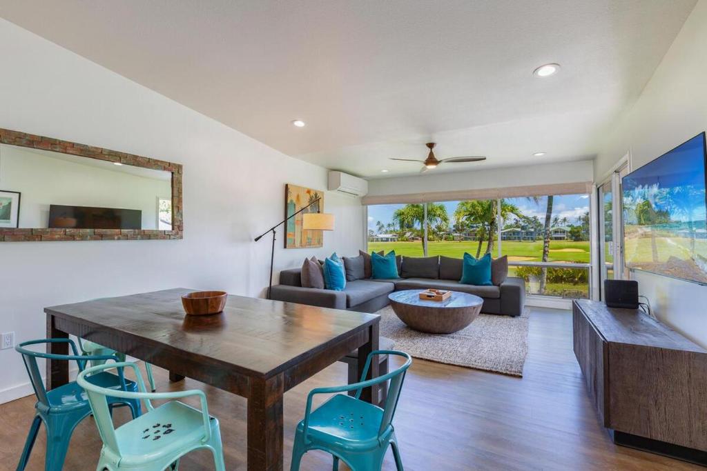 a living room with a table and chairs and a couch at Emmalani Court 322 in Princeville