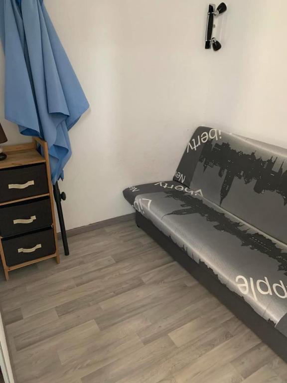 une chambre avec un lit et une commode dans l'établissement Petite maisonnette de vacances, à Gruissan