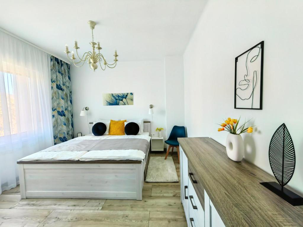 a white bedroom with a bed and a desk at City Vendégház Balatonfüred in Balatonfüred