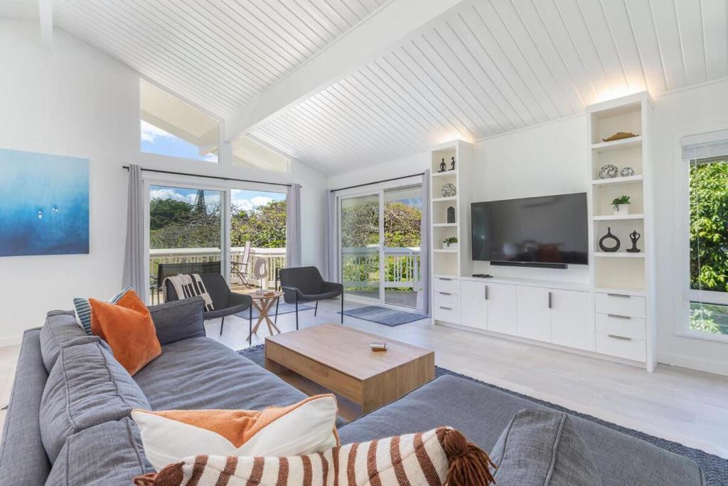 a living room with a couch and a tv at Hale Mauna Nui in Princeville