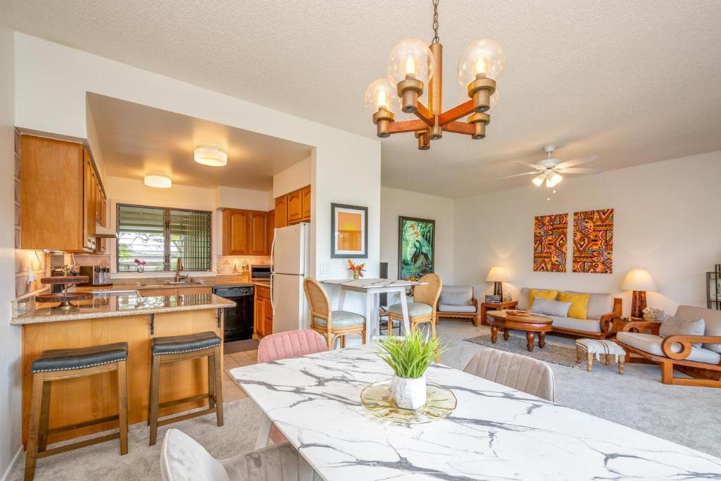 a kitchen and living room with a table and a dining room at Lae Nani 434 in Kapaa