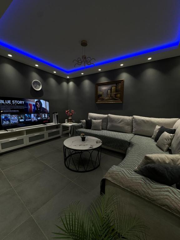 salon z kanapą i telewizorem w obiekcie Johns villa w mieście Artemida