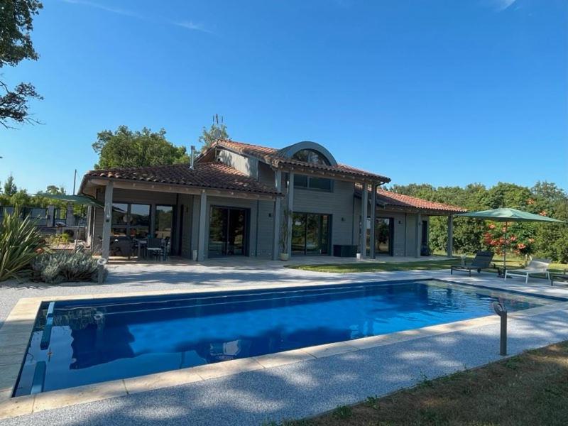 a house with a swimming pool in front of a house at Maison de campagne atypique in Monfort