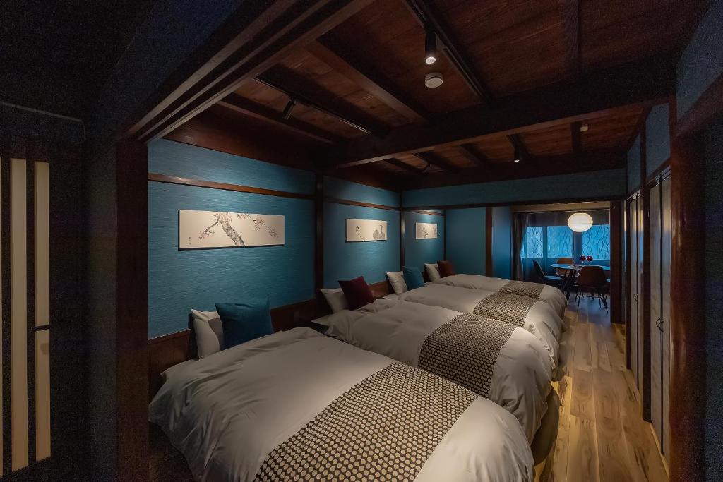 a bedroom with four beds in a room with blue walls at Higashiyama bau in Kanazawa