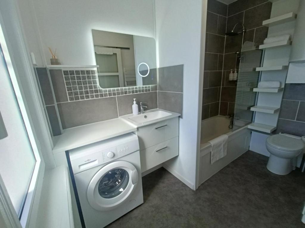a bathroom with a washing machine and a sink at Escapade Béthunoise in Béthune