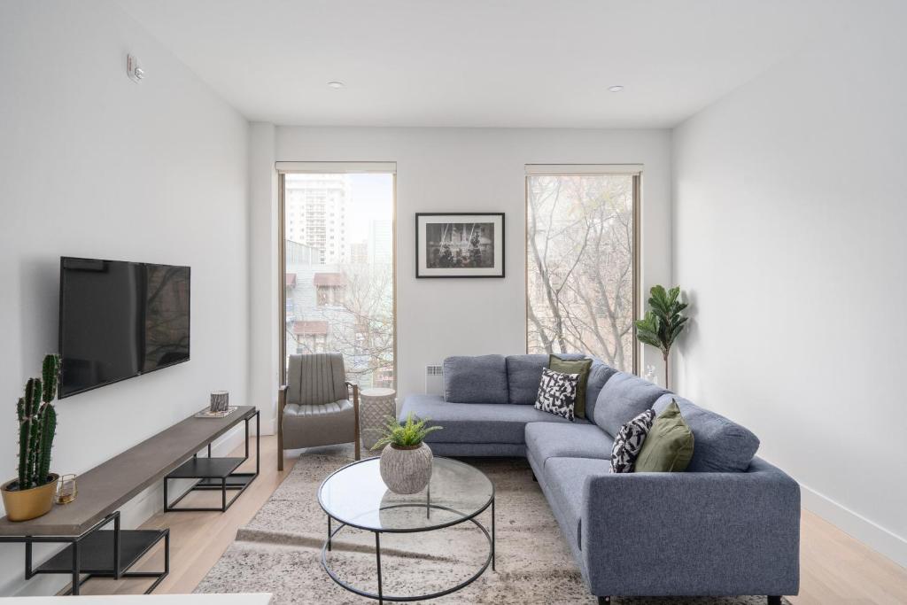 a living room with a blue couch and a tv at The S&D Apartments in Montréal
