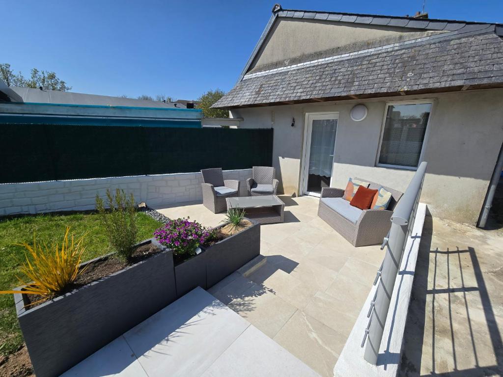 d'une terrasse avec des canapés et des chaises dans l'arrière-cour. dans l'établissement Maison rénovée avec jardin - Calme et confort à la campagne, à Saint-Thonan