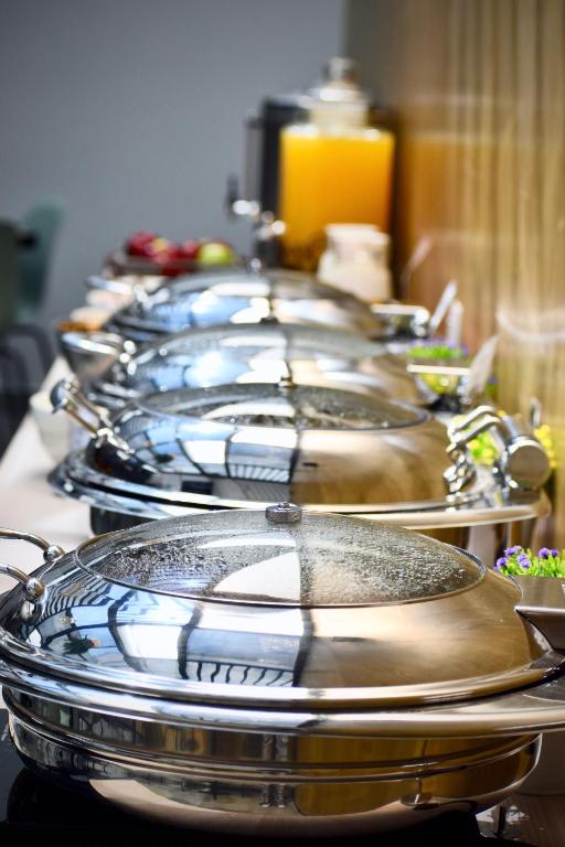 A close-up of covered stainless-steel dishes on the breakfast buffet.
