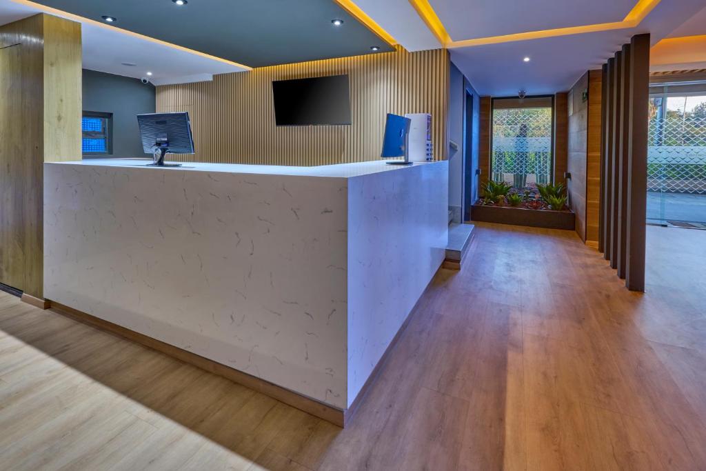 A modern reception area with a long white front desk and a bright entrance beyond.