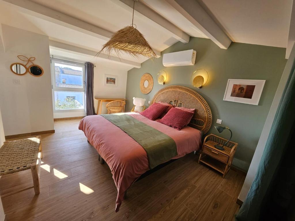 une chambre avec un grand lit avec des oreillers roses dans l'établissement Maison Mam Oléron, à Grand-Village-Plage