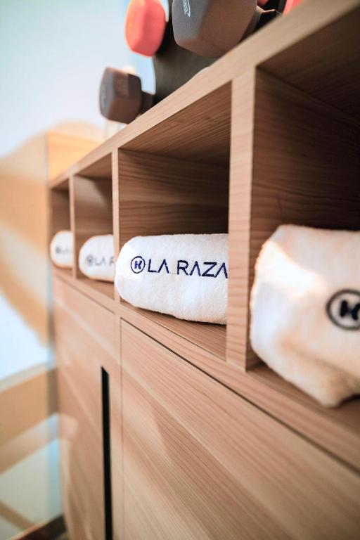 Open wooden gym shelving stocked with branded towels and weights above.