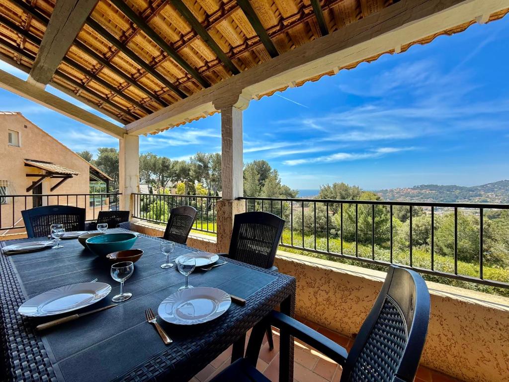 une table et des chaises sur un balcon avec vue dans l'établissement Grand Duplex - Terrasse Vue Mer, à Carqueiranne