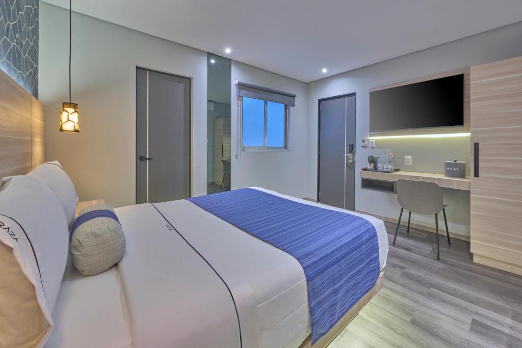 A modern bedroom showing the bed, desk, window, and adjoining bathroom doorway.