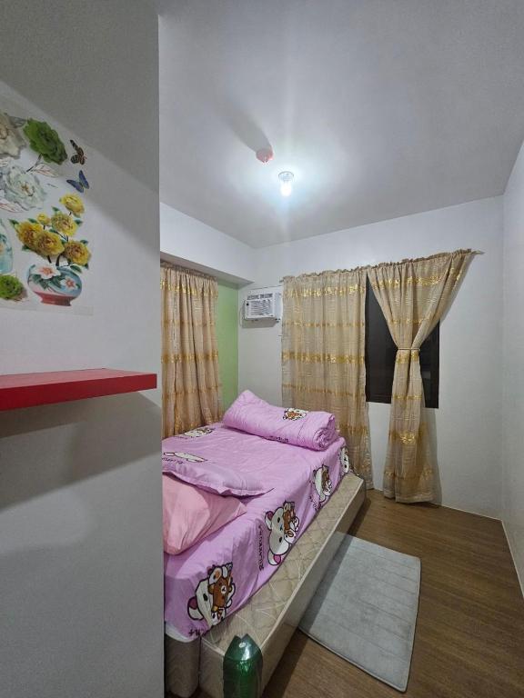 a bedroom with a bed and a window at Pine suite Condo Tagaytay in Tagaytay