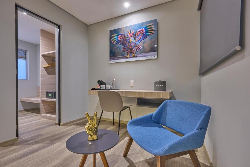 A guest-room work corner includes a narrow desk, chair, armchair, and coffee table.